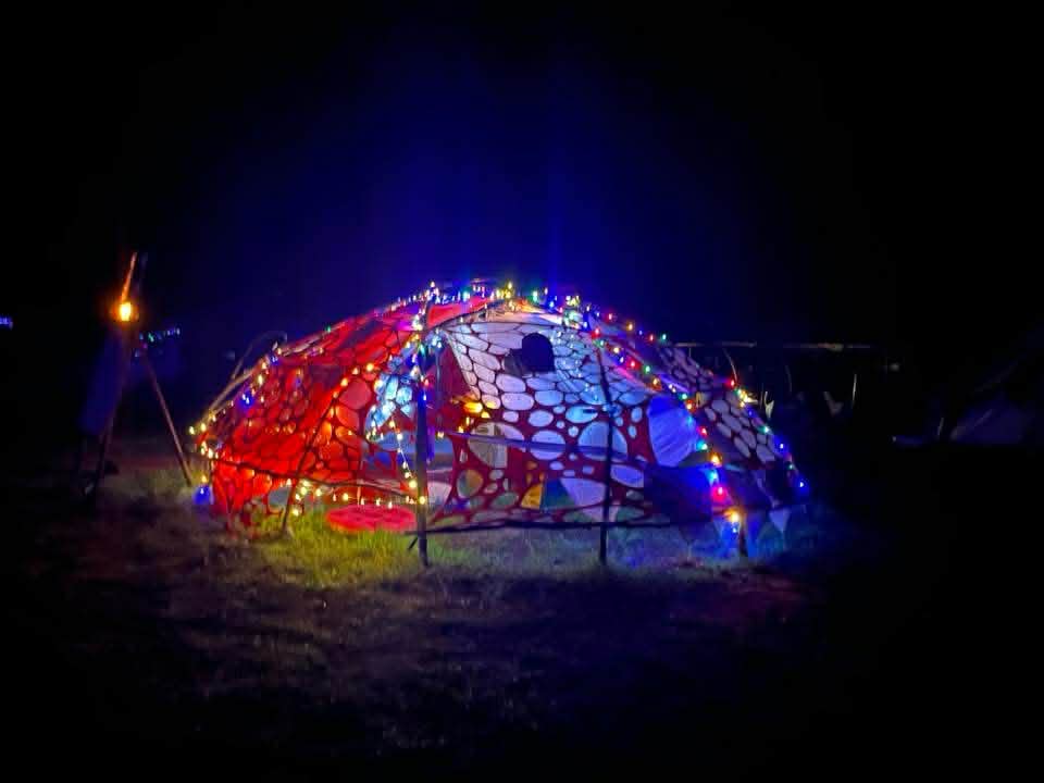 Altar of Passion dome exterior at night — colourful fairy lights
