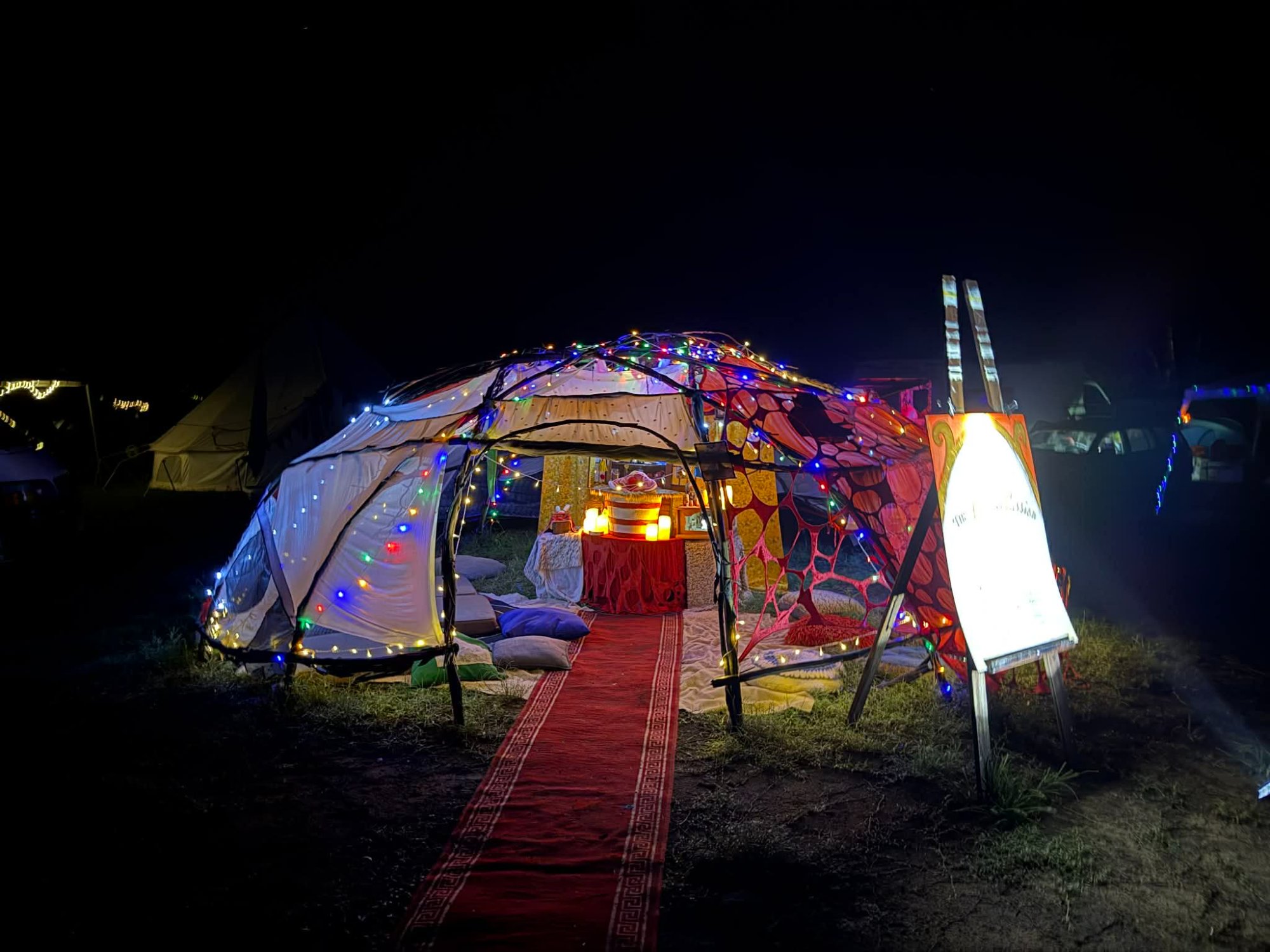 The Altar of Passion — exterior at night with red carpet entrance and fairy lights